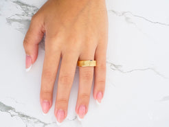 Gold wedding band on ring finger showcasing the classic fit of the Golden Whisper design