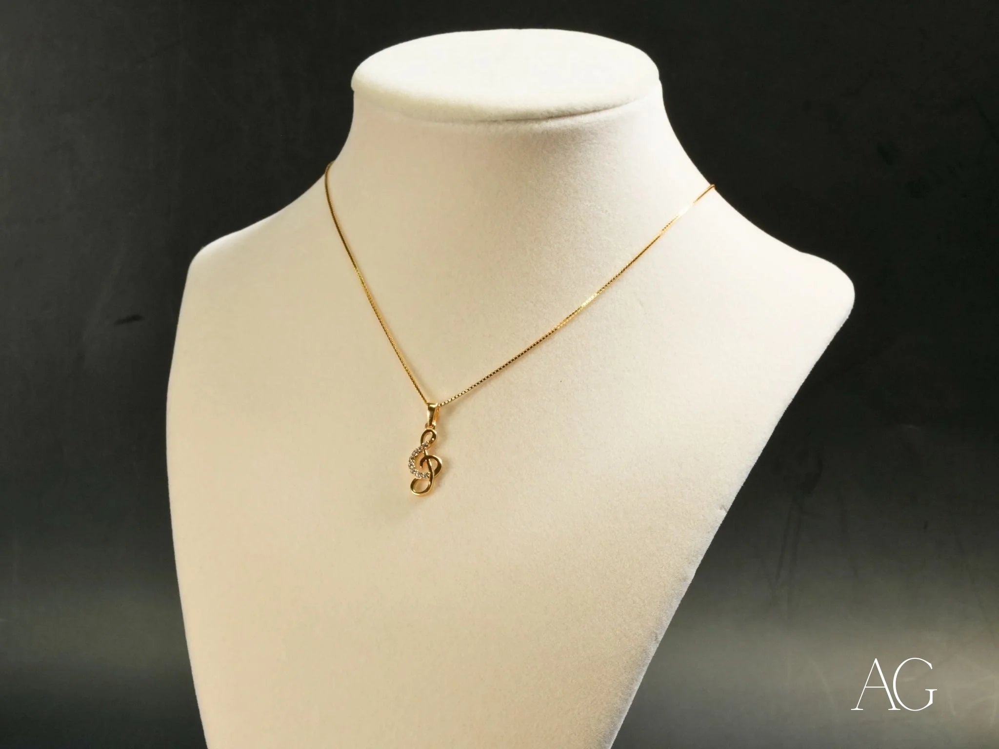 Gold necklace with treble clef pendant, part of the Harmonic Elegance collection