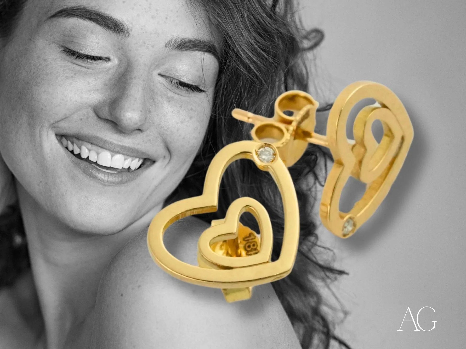 Gold heart-shaped earrings in 18k yellow gold featuring a dangling inner heart design