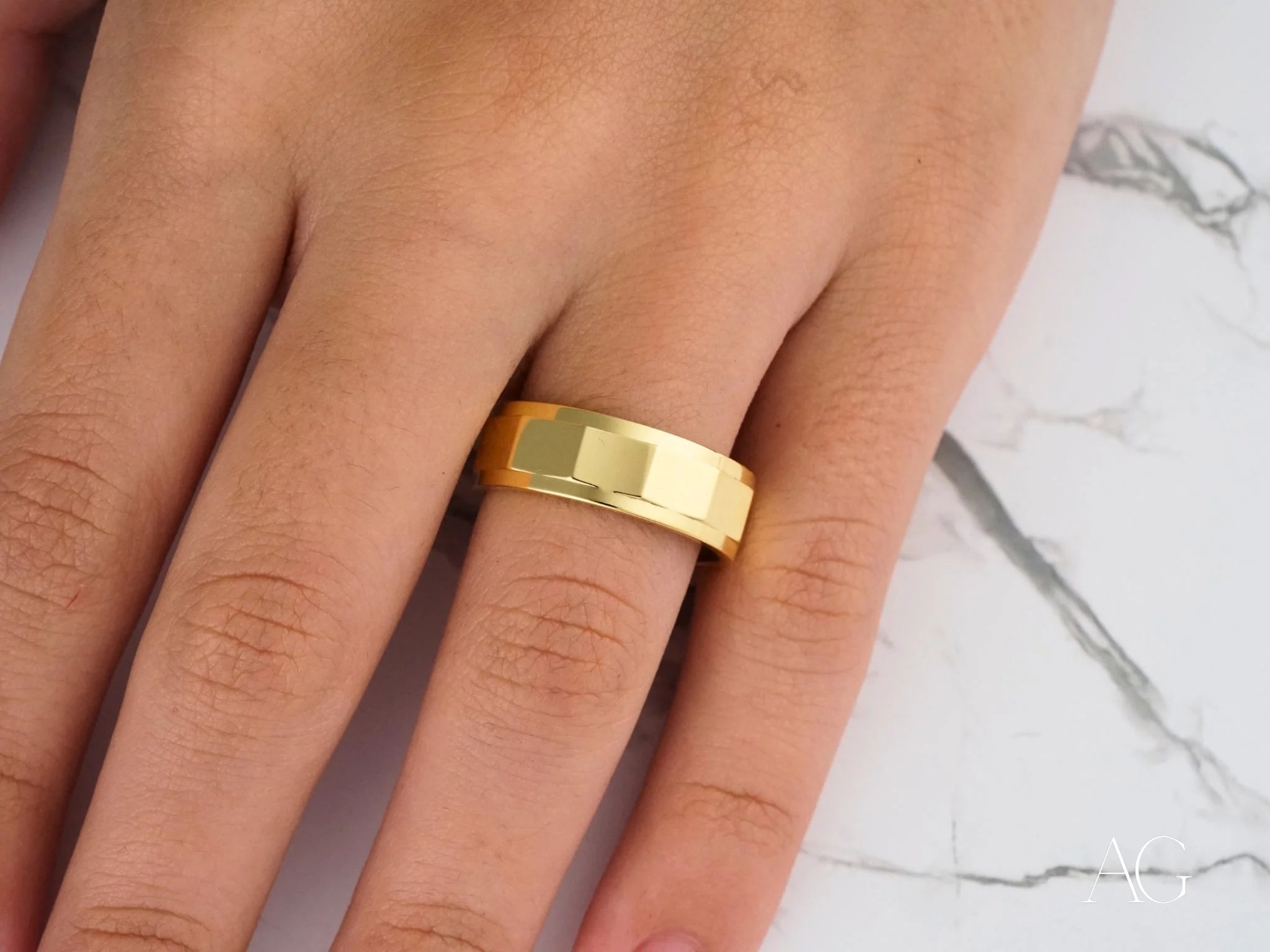 Gold signet ring on a finger featuring an Imperial Facet design in 14k gold