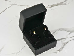 Gold stud earrings in a black jewelry box for Lustrous Harmony 18K Gold Pearl Drop Earrings
