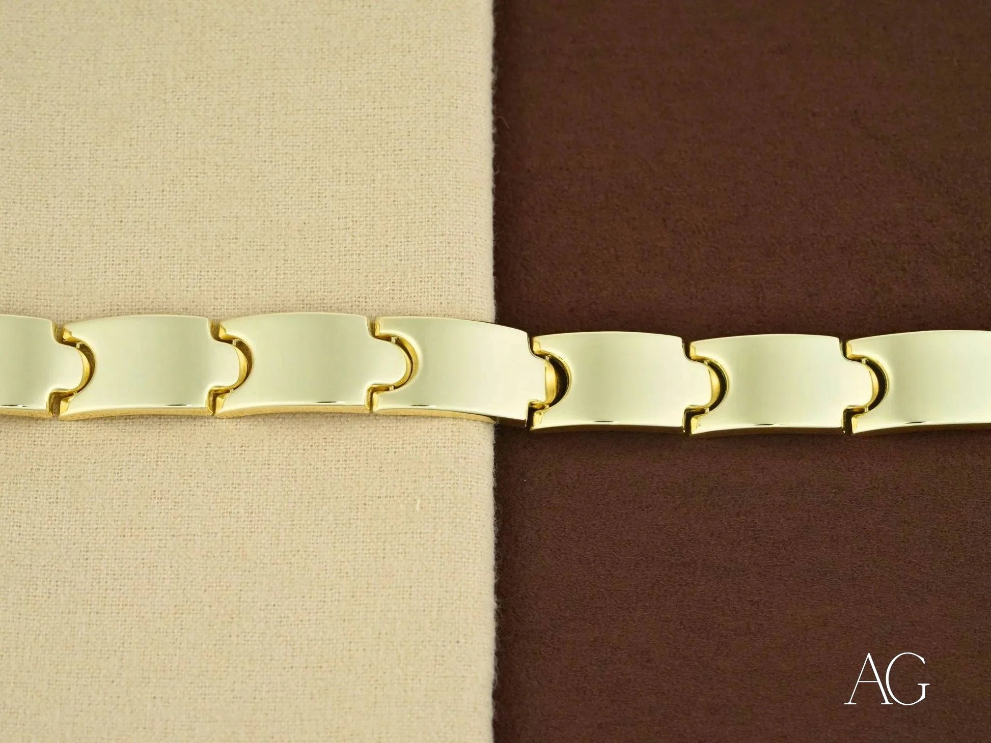 Interlocking cream-colored fabric belt with curved metal connectors on box clasp bracelet