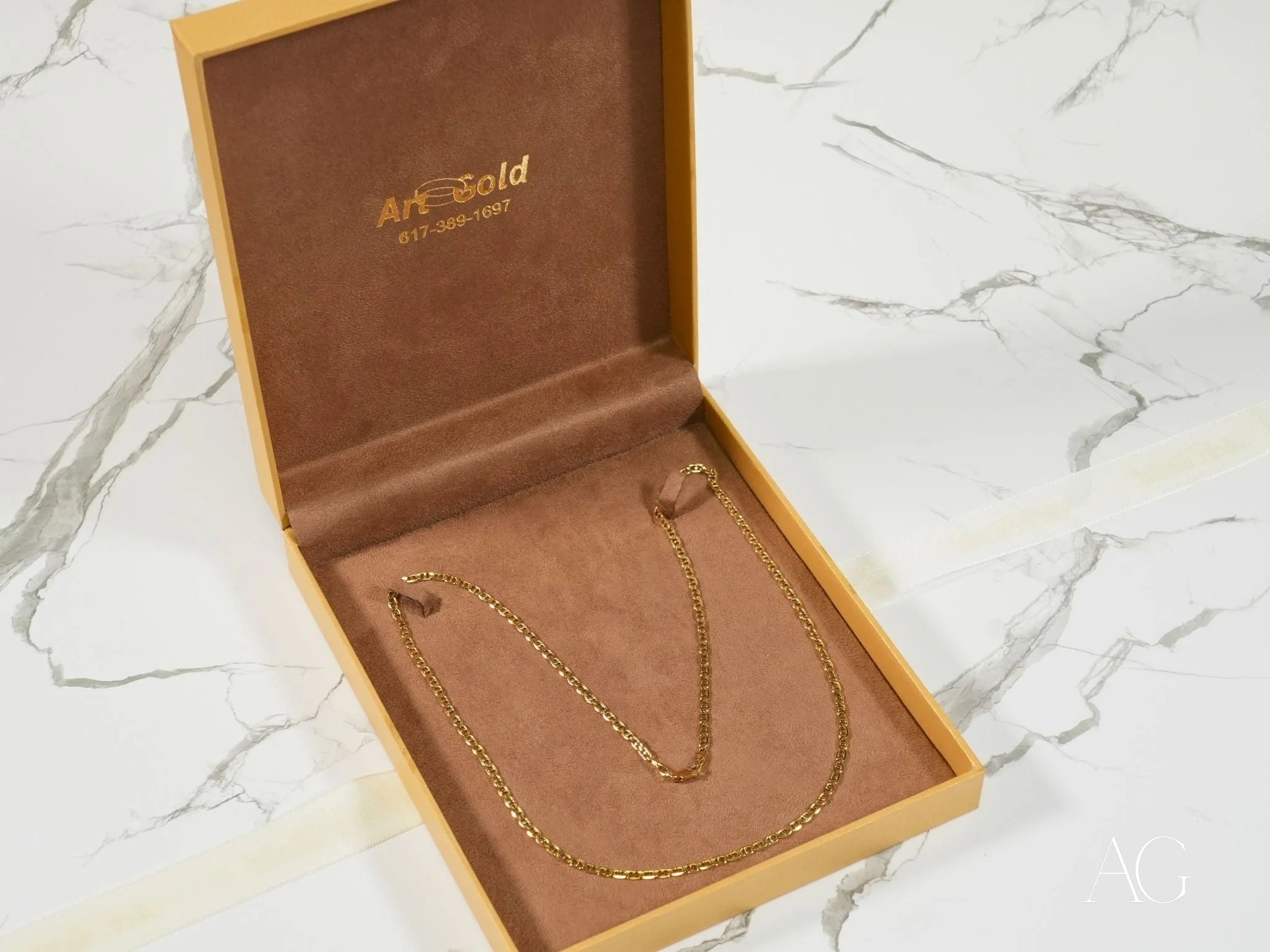 Gold chain necklace in a box showcasing Majestic Strength 18K Yellow Gold Anchor Chain