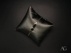 Black leather cushion with a delicate silver bracelet and Personalized 18k Gold Navy Link