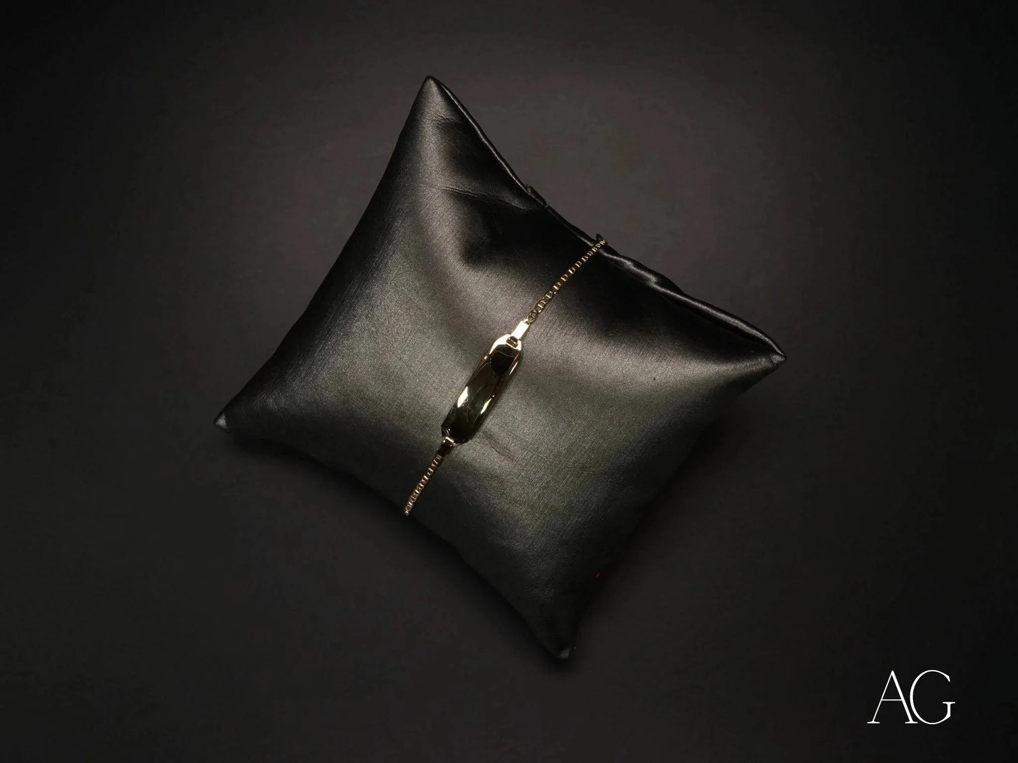 Black leather cushion with a delicate silver bracelet and Personalized 18k Gold Navy Link