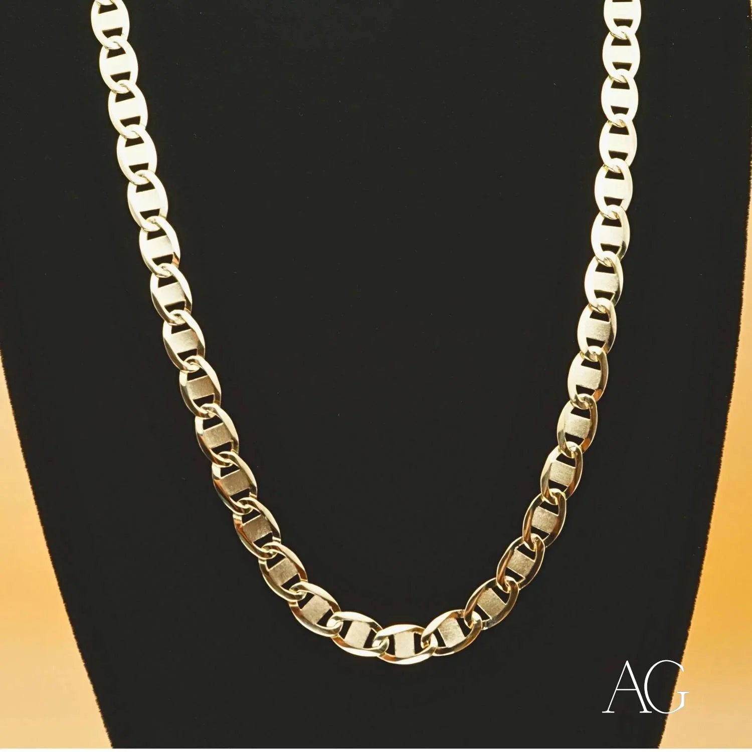 Gold chain necklace on a black jewelry stand showcasing Piastrine gold elegance