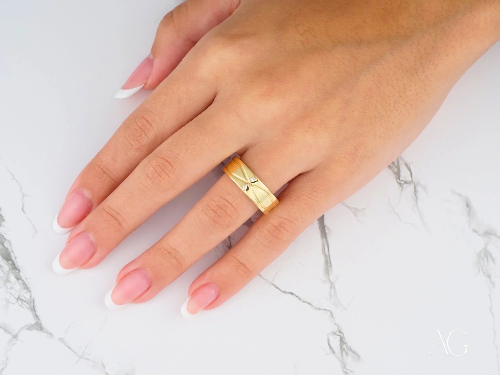 Gold Radiant Harmony wedding band with minimalist X design and comfort fit on a finger