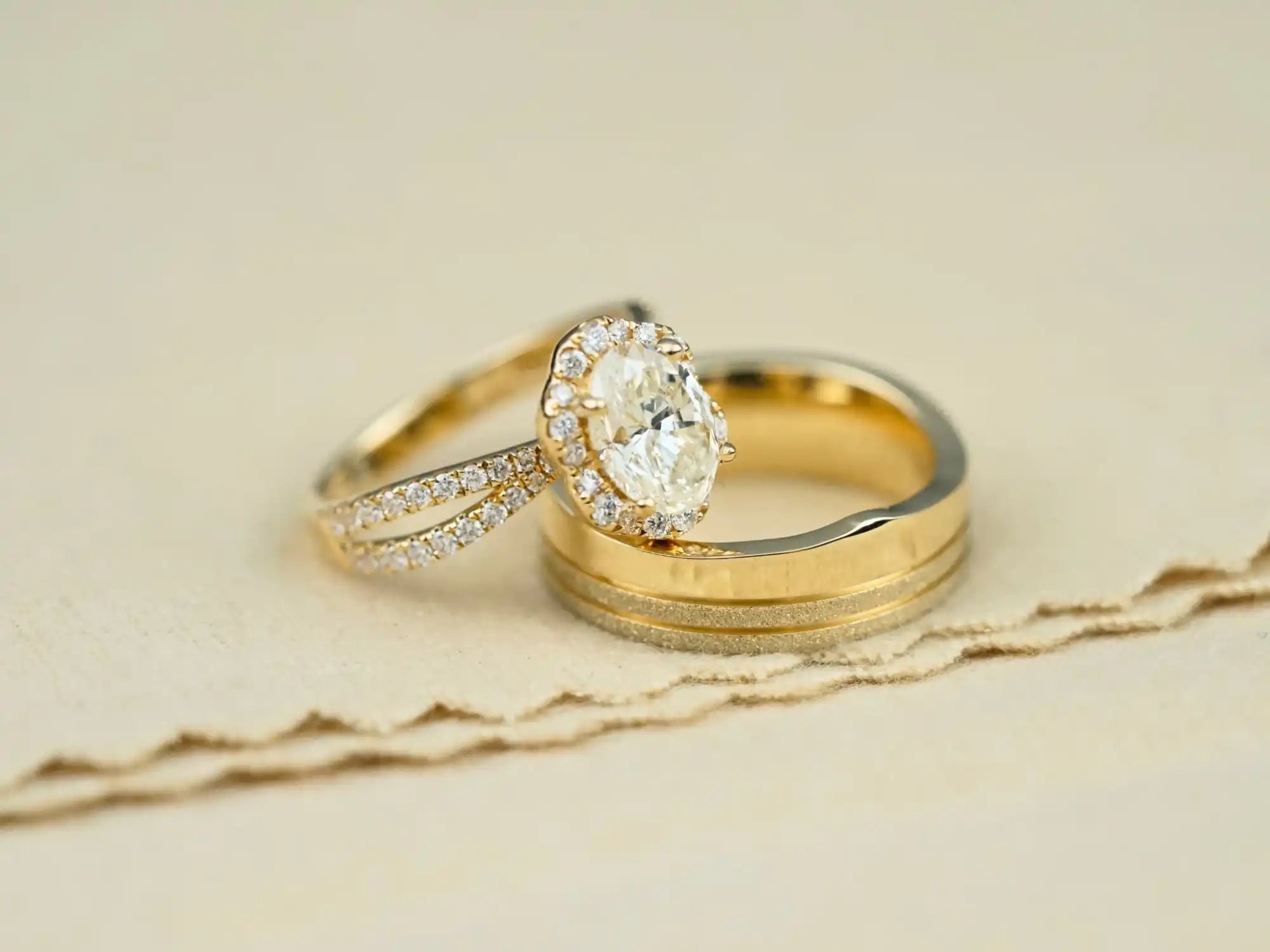 Wedding rings featuring a diamond engagement ring with pavé stones and a plain gold band.