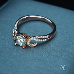 Elegant engagement ring in 18k rose gold with light blue gemstone and diamond accents