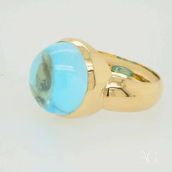 Gold ring with oval cabochon blue topaz gemstone in Serenity in Blue collection