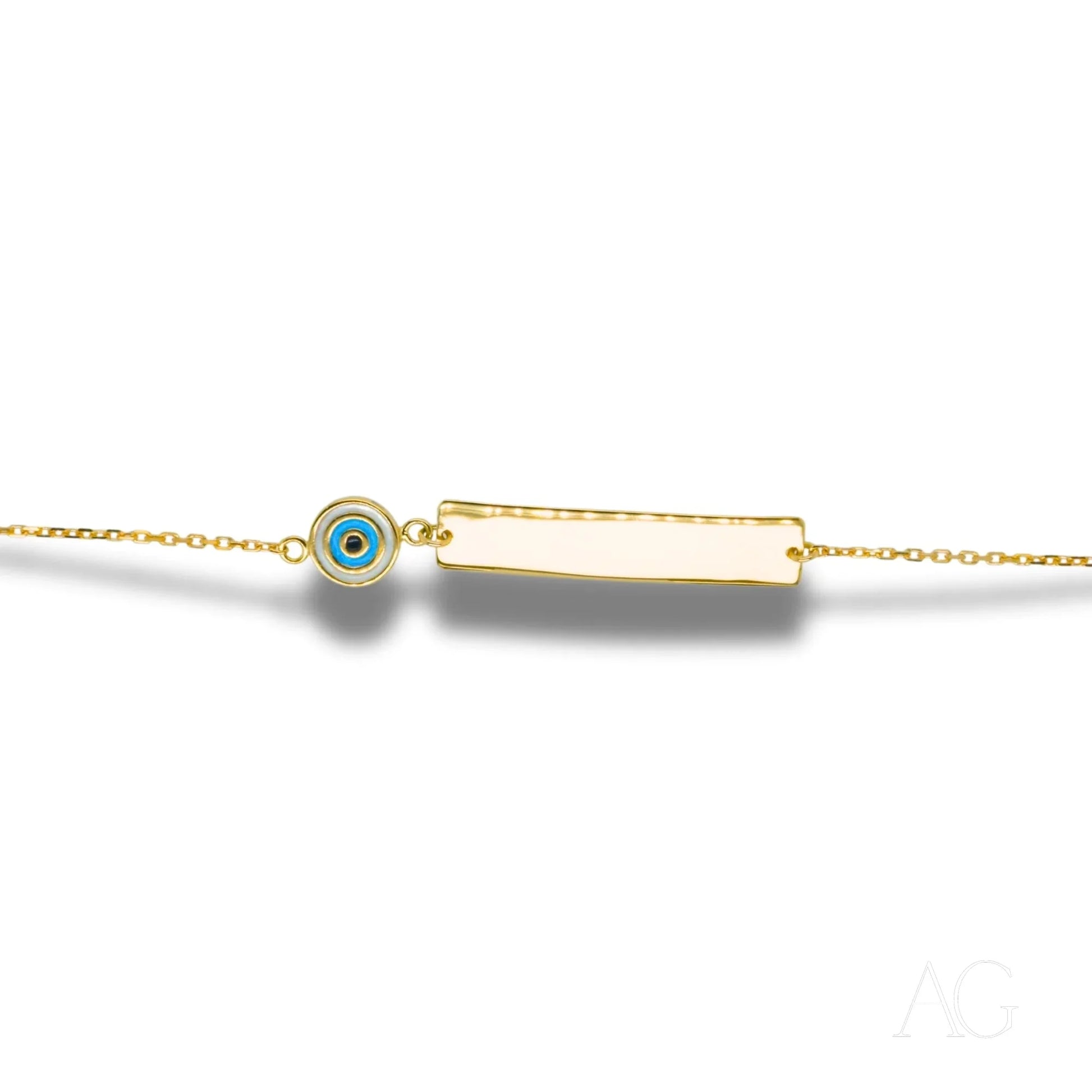 Delicate gold chain bracelet with rectangular bar charm and evil eye motif pendant