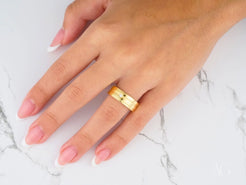 Gold wedding band on a ring finger from Solitaire Grace in 14k gold