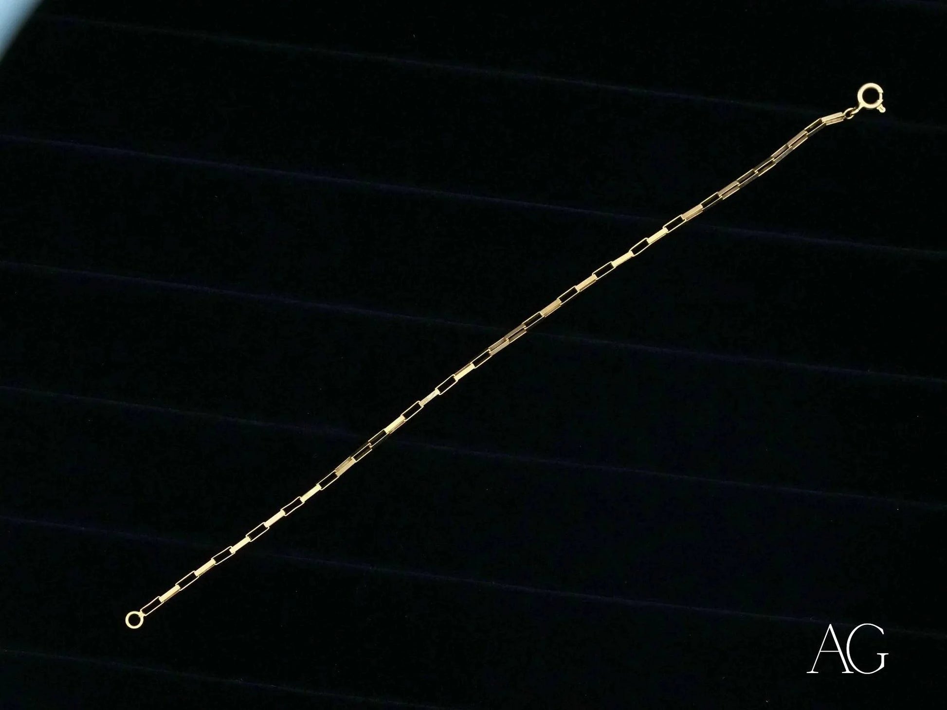 Delicate gold chain bracelet featuring solid 18k gold brick link design with small beads