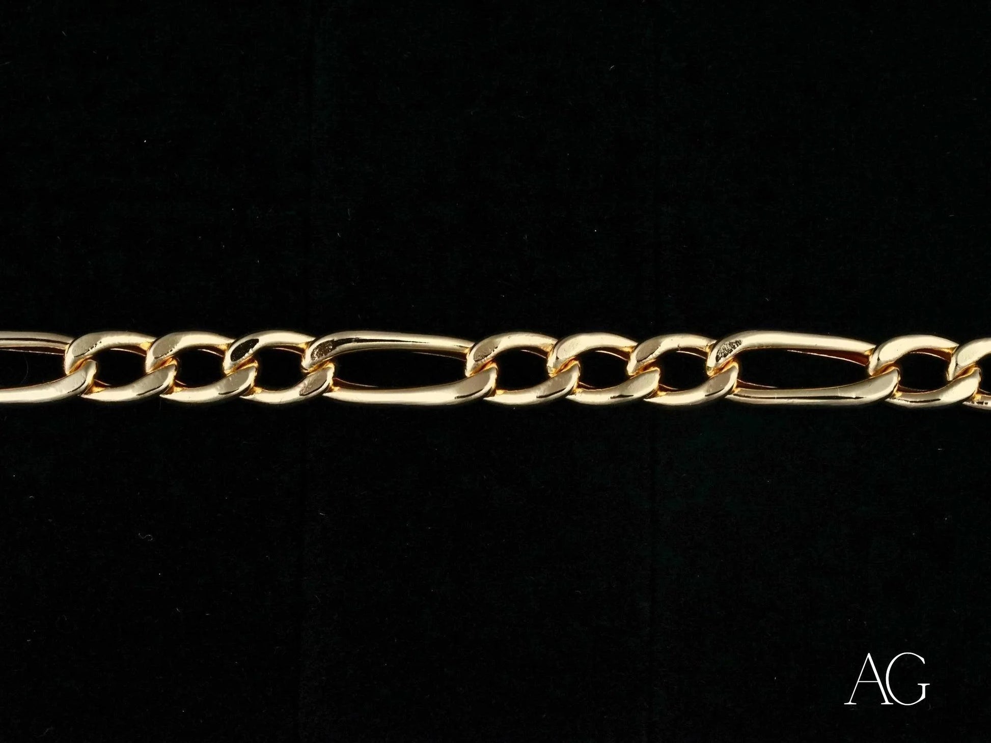 Gold-colored figaro bracelet with alternating long and short links in 18k gold