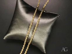 Gold chain necklace on black leather cushion showcasing solid 14k gold rope chain