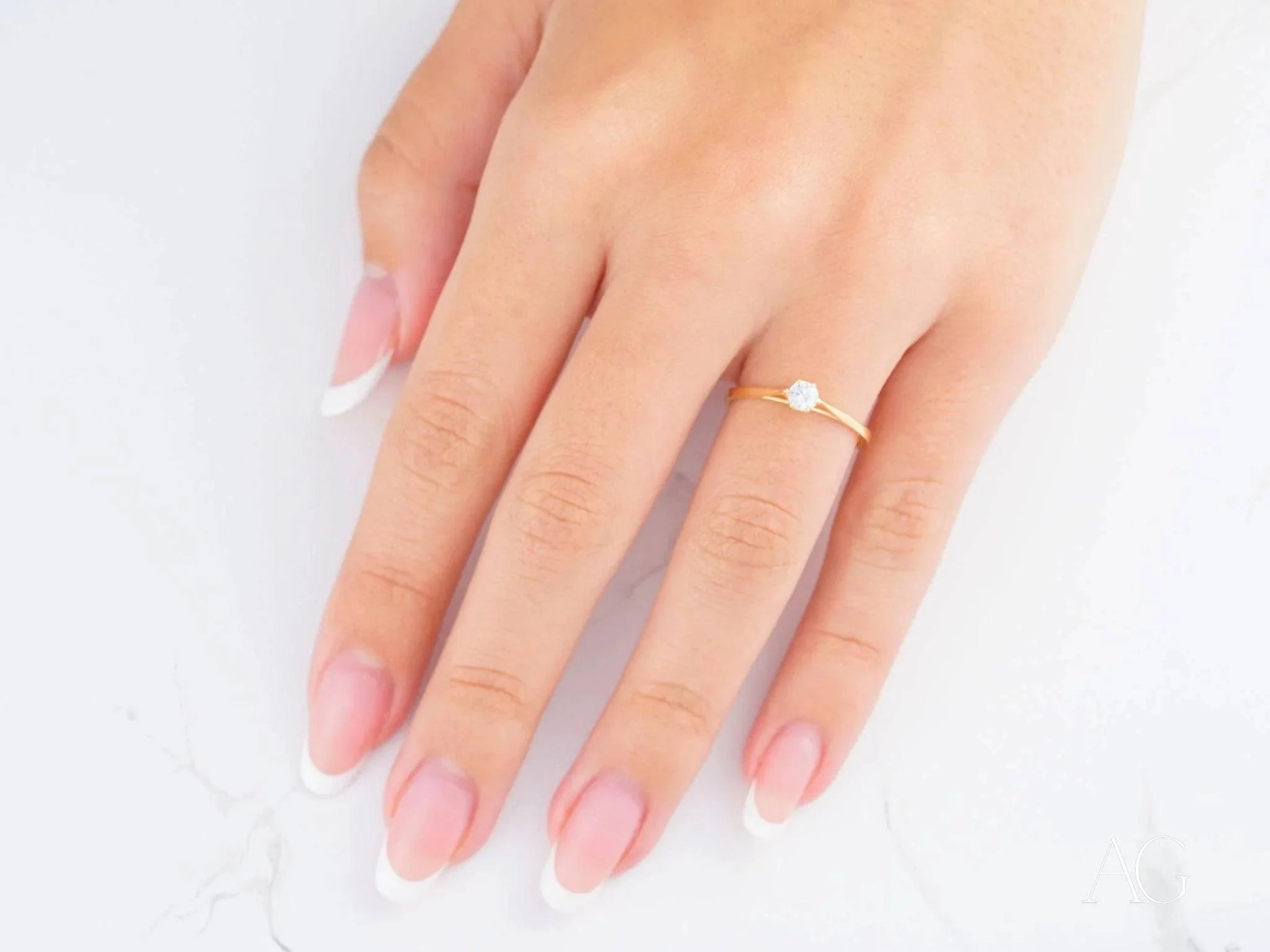 Delicate 18k yellow gold ring with a small pearl on a woman’s hand for everyday elegance