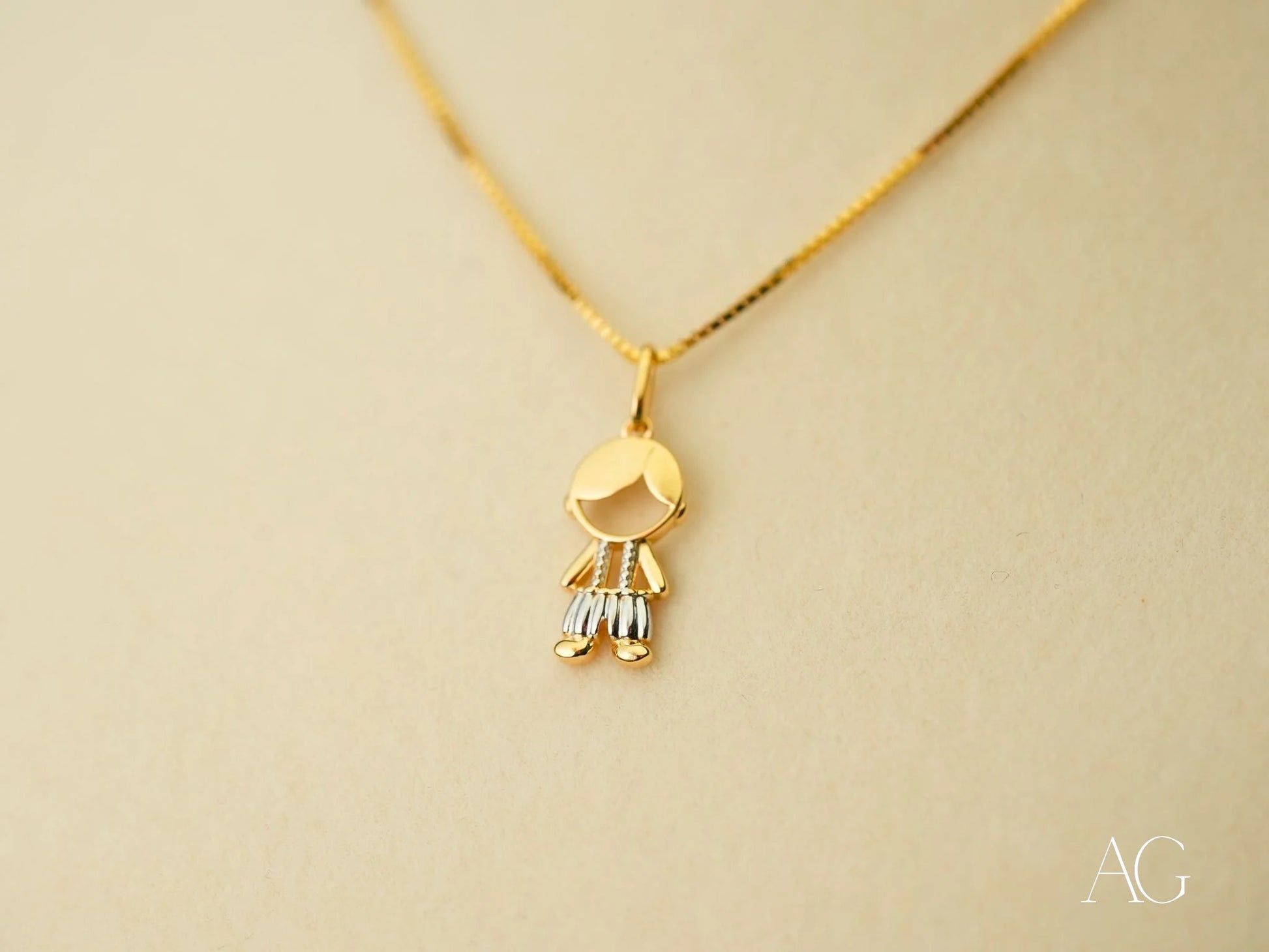 Gold pendant necklace featuring a stylized figure charm from the Timeless Charm collection