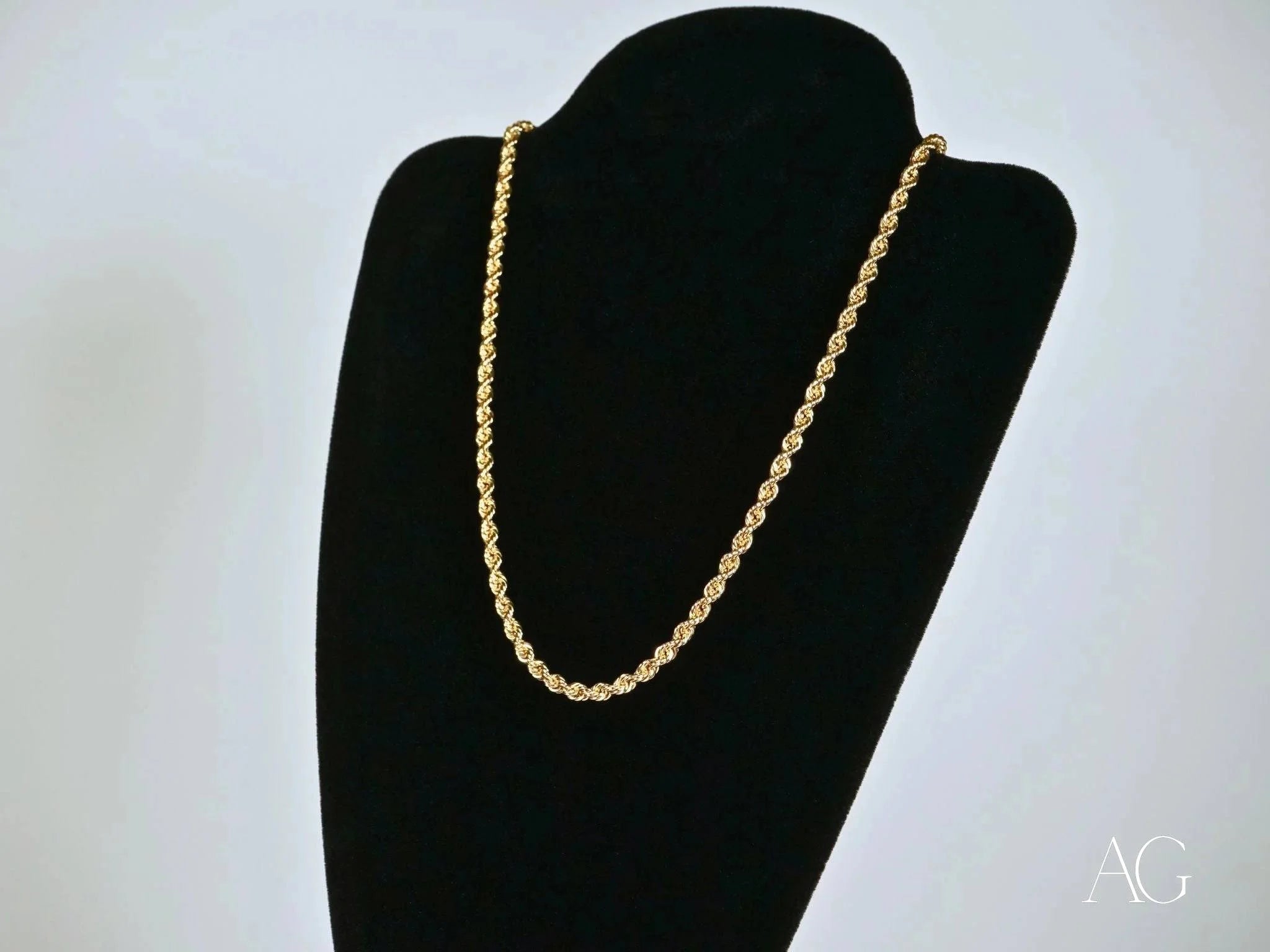 Gold rope chain necklace on a black jewelry bust, showcasing solid 14k gold elegance