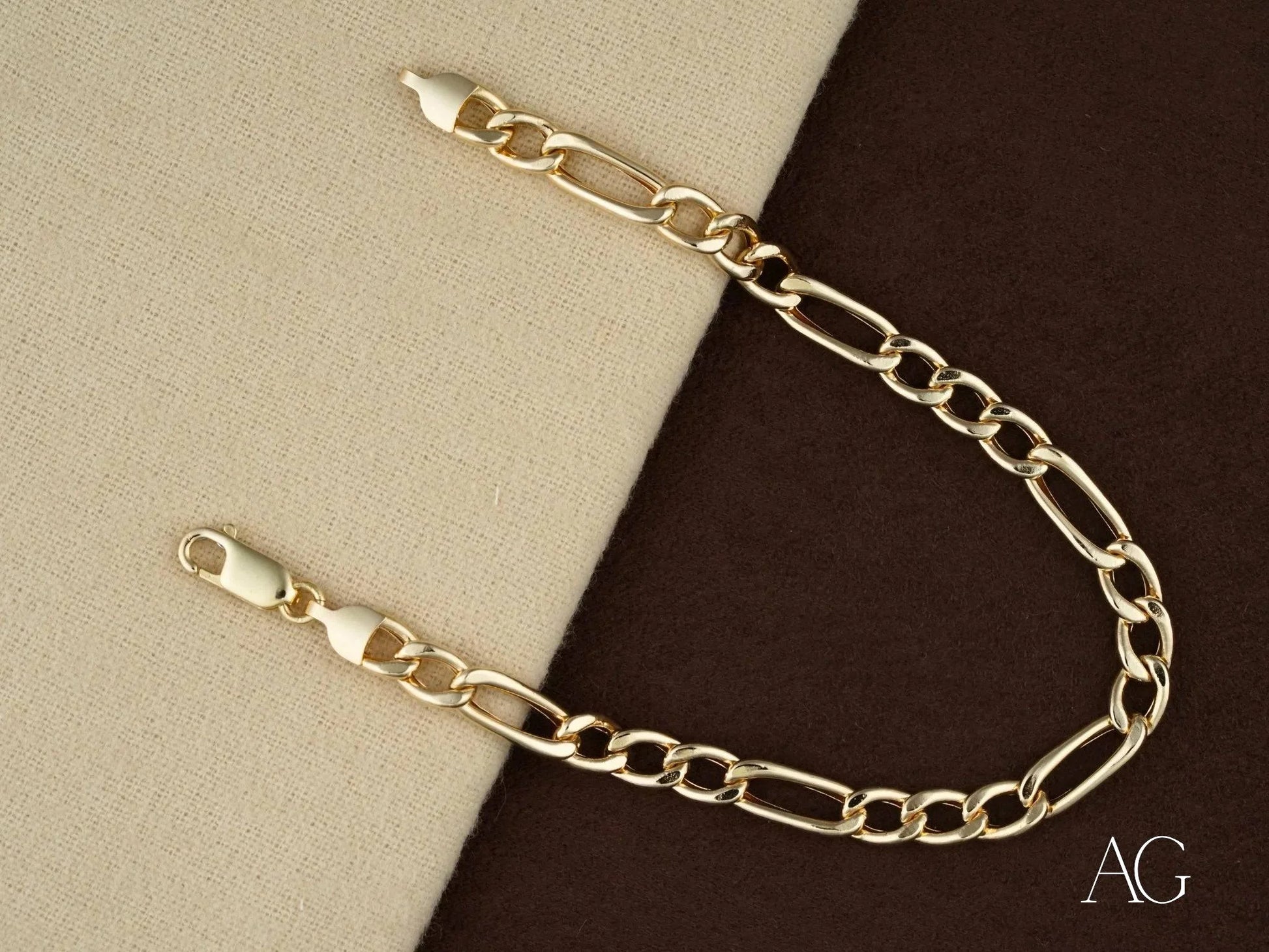 Gold-toned 18k gold figaro bracelet with alternating large and small links design