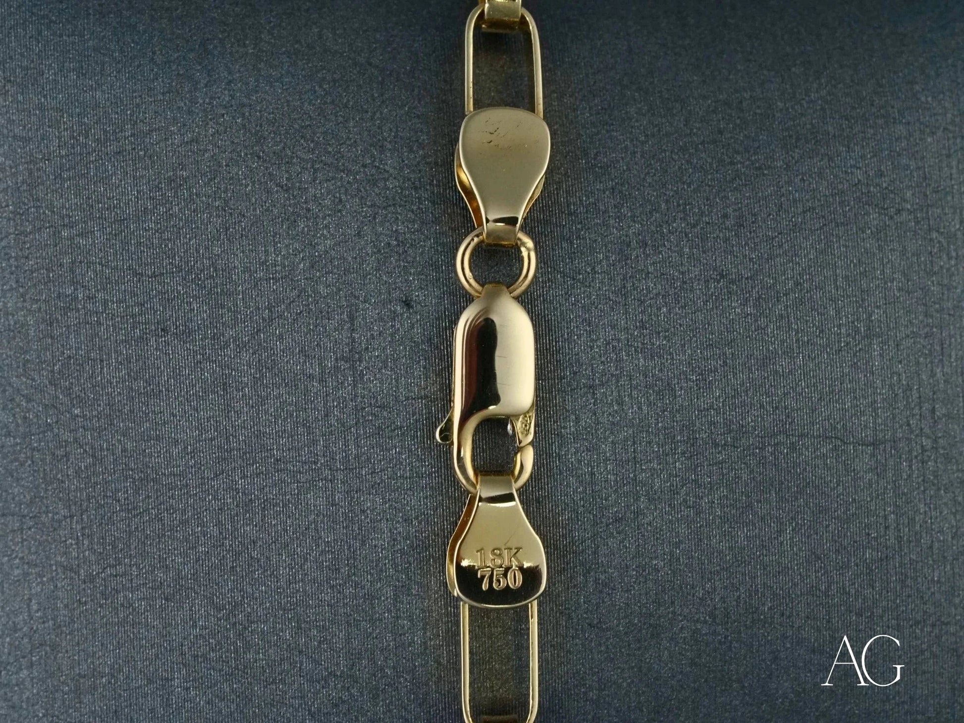 Gold lobster clasp on a box link segment of the 18k solid gold bracelet