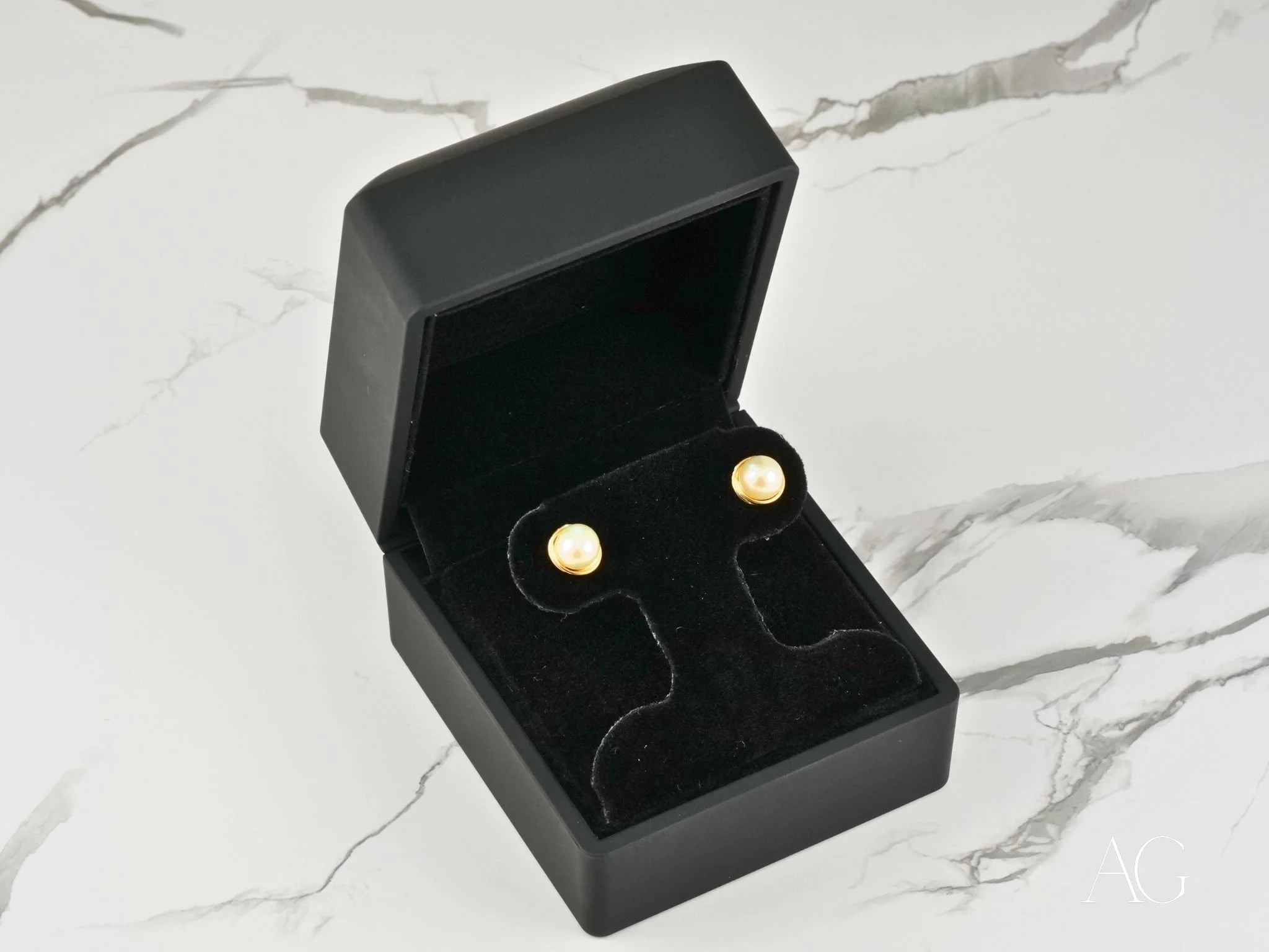 Pearl stud earrings in a black jewelry box, part of Timeless Radiance Gold Jewelry