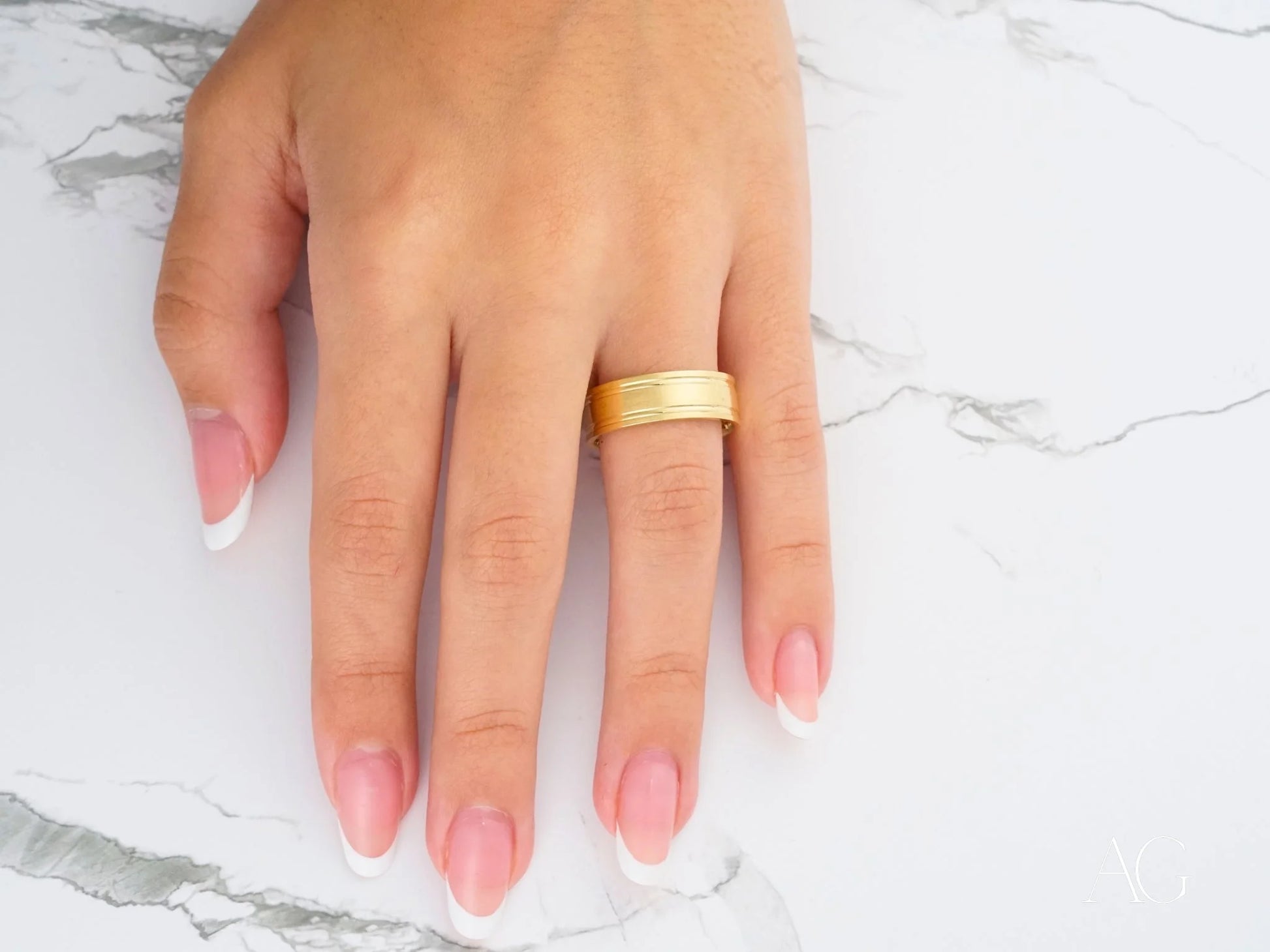 Gold wedding band with pink nails, showcasing the elegant Twin Promise design in 14k gold