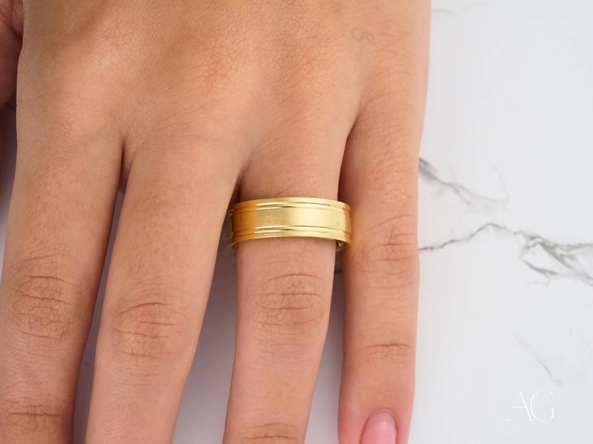 Gold wedding band on finger, showcasing the elegant Twin Promise design in 14k gold