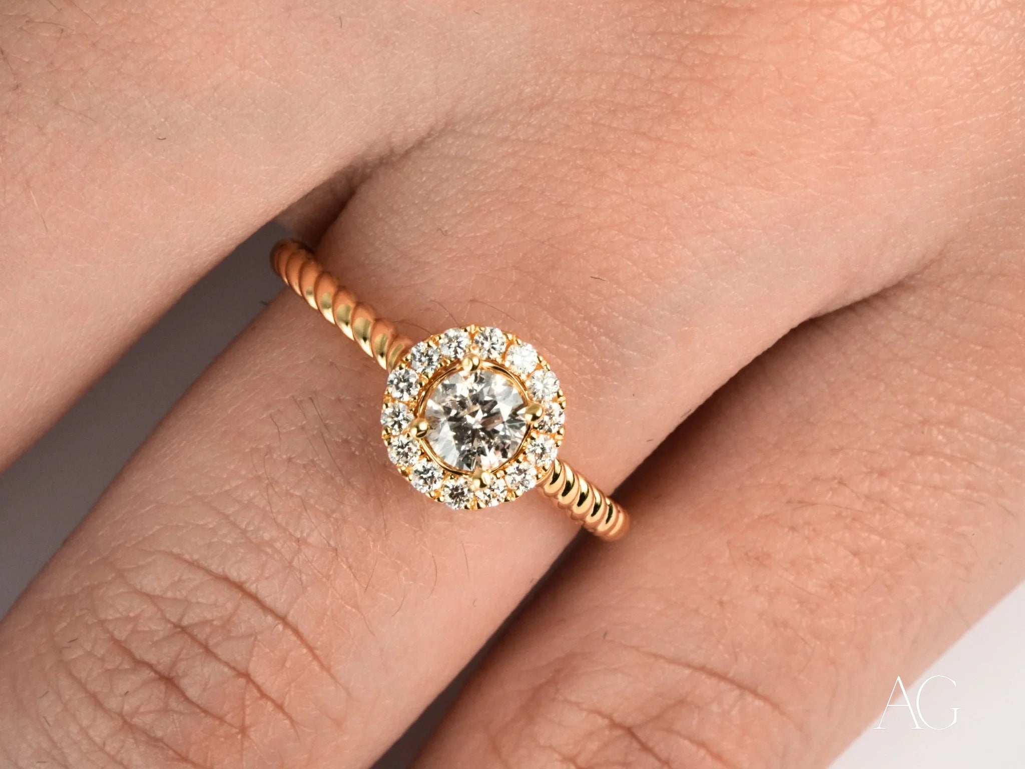 Gold engagement ring featuring a round center diamond and halo setting with smaller diamonds