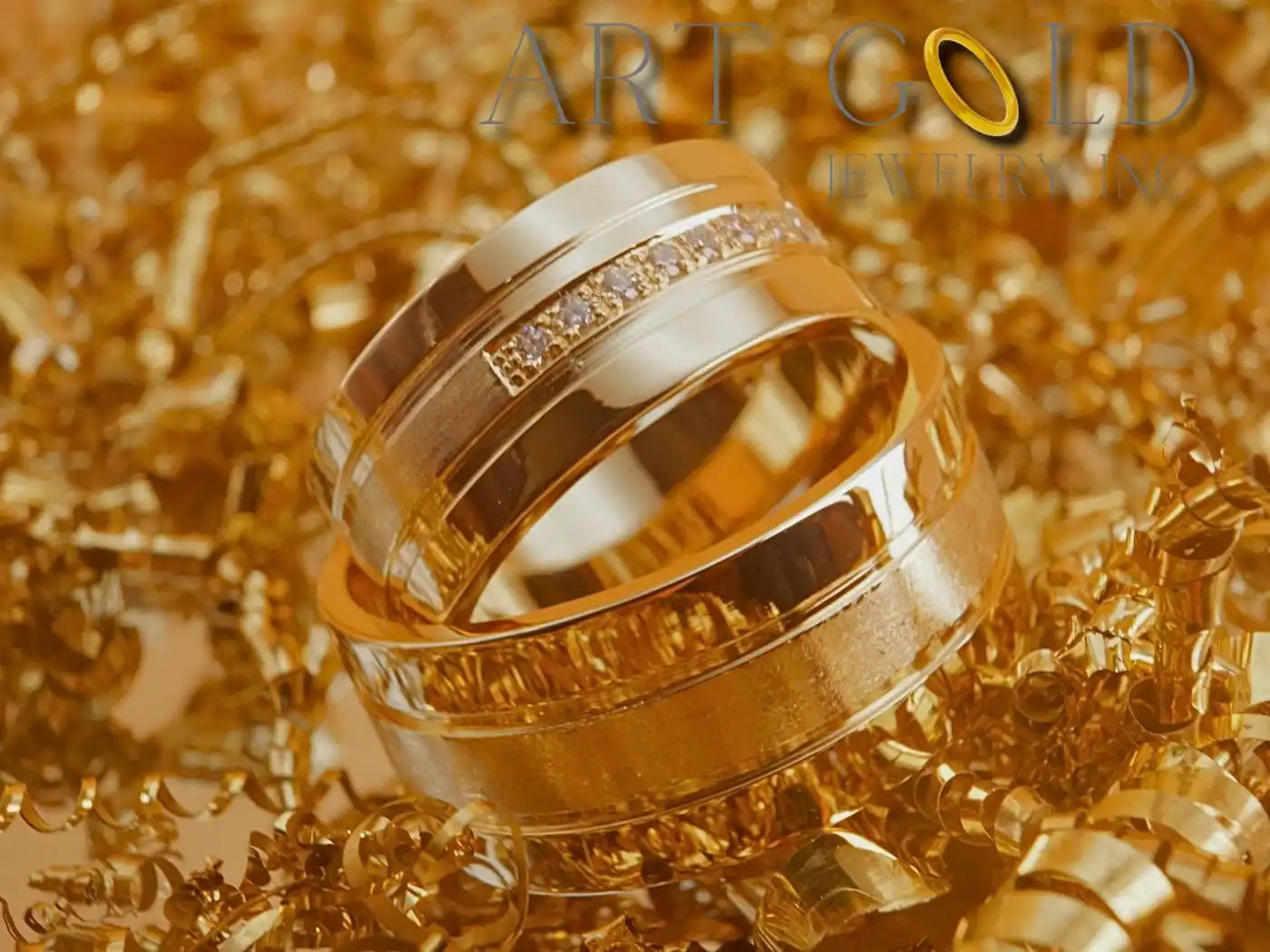 Two gold wedding rings nestled together on a glittery surface.