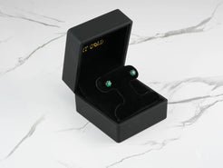 Emerald stud earrings in a black jewelry box for Verdant Sparkle 18k Gold Green CZ