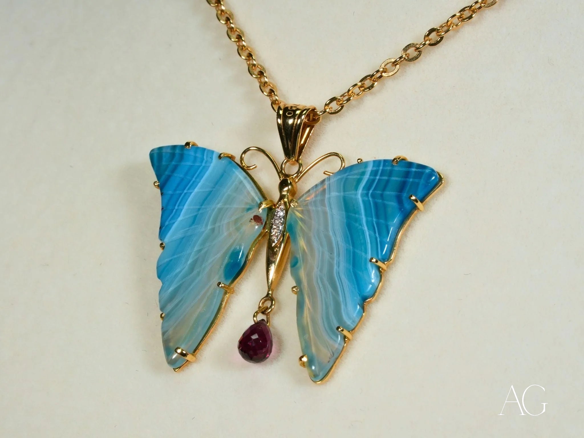 Butterfly pendant in blue agate with purple crystal drop and 18k yellow gold accents