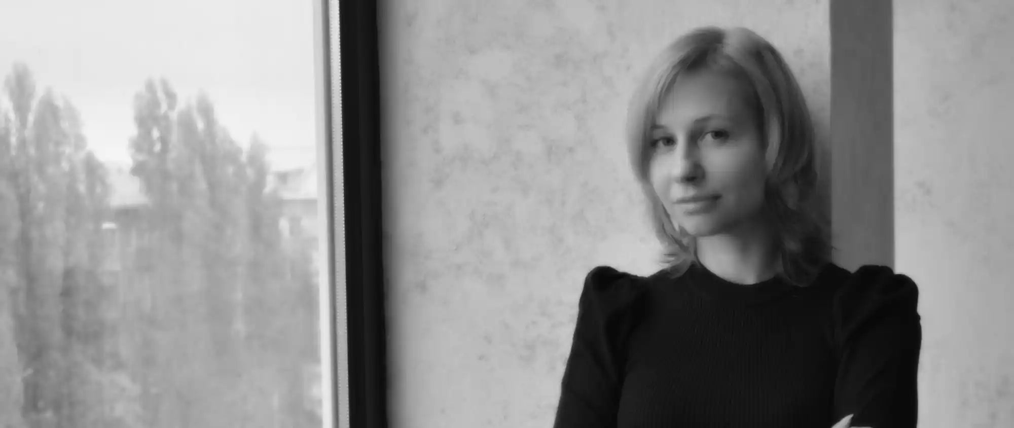 A woman in a black dress photographed in black and white.