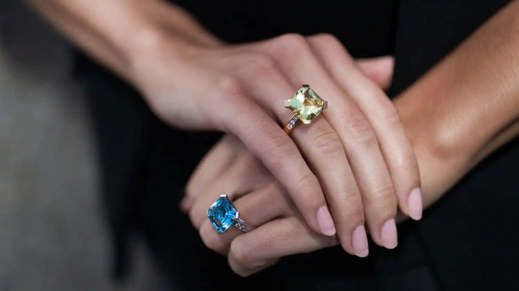 Woman’s hands adorned with gemstone rings.