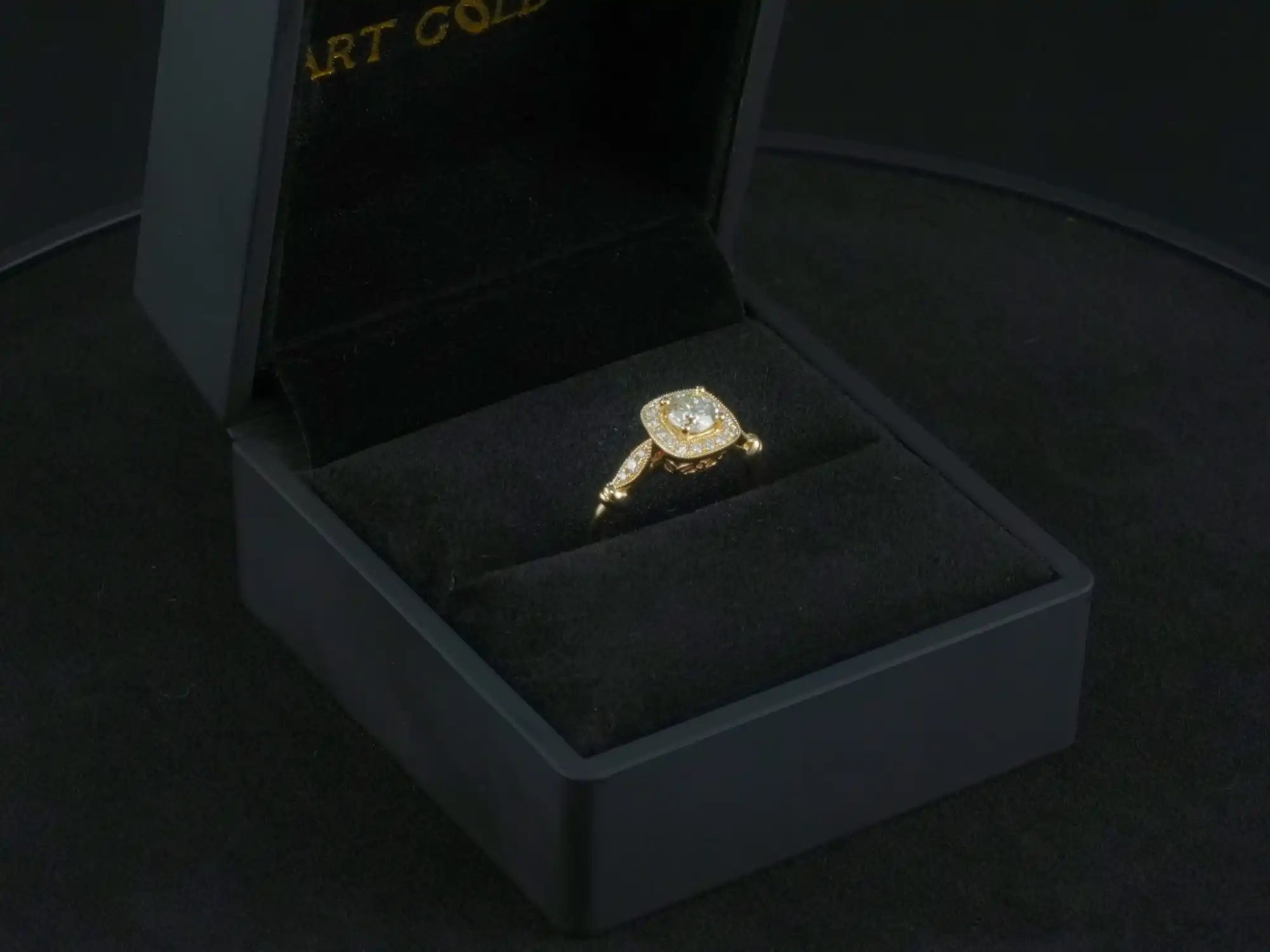 Yellow gold engagement ring with a center diamond in a black jewelry box.